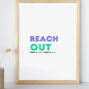Puede incluir: Una impresión enmarcada con el texto "REACH OUT" en letras moradas y verdes. El texto "THERE IS HOPE THERE IS HELP" está escrito en letras más pequeñas debajo del texto principal.