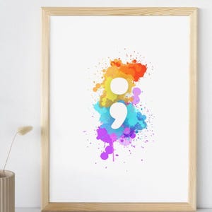 May include: A framed print with a white semicolon symbol in the center of a colorful watercolor splatter design. The colors in the splatter are orange, yellow, blue, purple, and pink.
