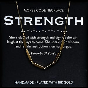 May include: Gold necklace with a pendant that spells out "STRENGTH" in Morse code. The necklace is on a black background with the text "MORSE CODE NECKLACE" and "HANDMADE - PLATED WITH 18K GOLD". The text "She is clothed with strength and dignity; she can laugh at the days to come. She speaks with wisdom, and faithful instruction is on her tongue. Proverbs 31:25-28" is also on the background.