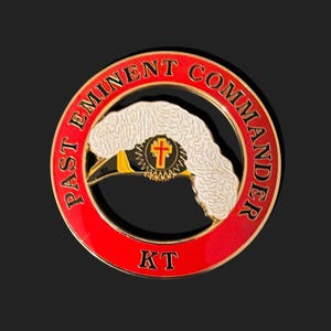 Könnte beinhalten: Ein kreisförmiges Emblem mit rotem Rand und den Worten "PAST EMINENT COMMANDER" in Rot. Die Mitte zeigt ein weißes Federdesign, ein Kreuz und die Buchstaben "KT".