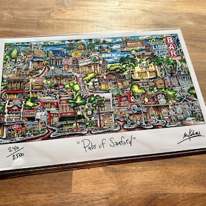May include: A colorful illustration of a city scene with the title "Pubs of Sanford" and the number 240/250 printed in the bottom left corner. The image is signed by the artist, M. Kihm, in the bottom right corner.