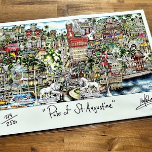 May include: A colorful print titled "Pubs of St. Augustine" featuring a detailed illustration of a city scene with buildings, boats, and palm trees. Two lion statues are in the foreground. The print is numbered 219/2500.