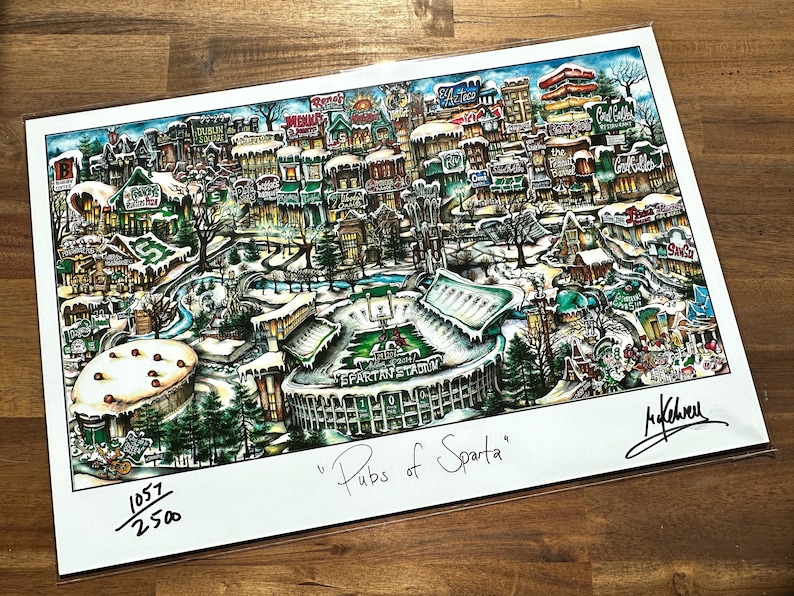 K&ouml;nnte beinhalten: Eine farbenfrohe Illustration einer Winterszene in East Lansing, Michigan, mit Fokus auf das Spartan Stadium. Die Illustration tr&auml;gt den Titel "Pubs of Sparta" und ist mit 1057/2500 nummeriert.