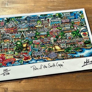 May include: A colorful, hand-drawn illustration of a map of the South Cape, featuring various buildings, shops, and businesses. The map is titled "Pubs of the South Cape" and is numbered 144/2500.
