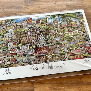 May include: A colorful illustration of a city scene with buildings, streets, and people. The title "Pubs of Tallahassee" is written in black ink at the bottom of the print. The print is numbered 848/2500.