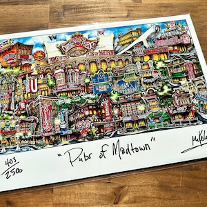 May include: A colorful illustration of a city scene with the text "Pubs of Madtown" and the number "403/250". The illustration features buildings, streets, and people in a whimsical style.