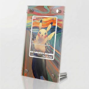 Könnte beinhalten: Ein transparenter Acryl-Displayrahmen mit einer japanischen Pikachu-Sammelkarte vor einem farbenfrohen, wirbelnden Hintergrund, der an das Gemälde Der Schrei erinnert. Die Karte zeigt den Text Pikachu, 60 KP und verschiedene Spielstatistiken.