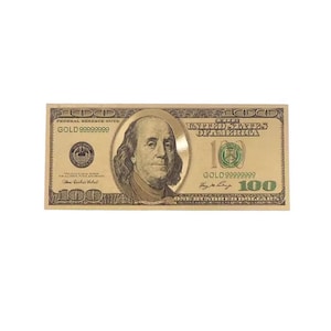 Könnte beinhalten: Ein goldfarbener 100-Dollar-Schein mit einem Porträt von Benjamin Franklin. Der Schein trägt den Text "FEDERAL RESERVE NOTE" und "GOLD 999999999". Der Schein trägt auch den Text "ONE HUNDRED DOLLARS".