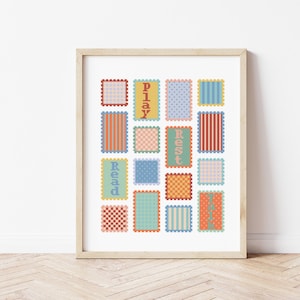May include: A framed art print with a design of colourful rectangular blocks. The blocks feature patterns and the words "Play", "Rest", and "Read". The colours include orange, blue, green, and pink, creating a vibrant and playful design.