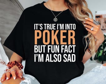 May include: Black t-shirt with white text that reads "It's true I'm into poker but fun fact I'm also sad". The word "poker" is in orange.