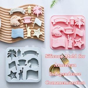 Könnte beinhalten: Zwei quadratische Silikonformen und ein Set aus geformten Objekten mit patriotischen amerikanischen Symbolen wie einem Adler, der Freiheitsstatue, einer Flagge, einem Feuerwerk, einem Stern und einem Zylinder. Der Text Silicone Mold for American Independence Commemoration ist sichtbar.