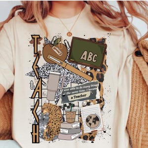May include: Beige t-shirt with a graphic design featuring school-related elements. The design includes an apple, a chalkboard with "ABC", a coffee cup, books, and the text "I was able to do many things at the same time. I became a Teacher."