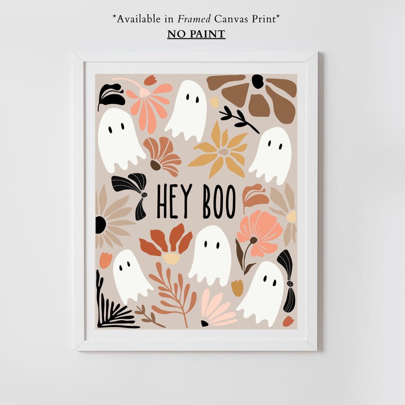 May include: A framed print featuring a beige background with white ghost illustrations and floral designs in shades of brown, peach, and yellow. The phrase "HEY BOO" is written in black. The print is in a white frame.