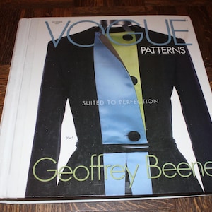 May include: A Vogue Patterns magazine cover featuring a black jacket with a light blue and lime green front panel. The text reads Vogue Patterns, Suited to Perfection, 2045, and Geoffrey Beene. The magazine has a white spine and a white border.