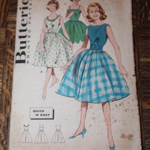 May include: Vintage Butterick printed pattern featuring illustrations of dresses. The cover shows three women in dresses, including a blue and white plaid dress. The text "QUICK 'N EASY" is visible, along with the pattern number 9369.