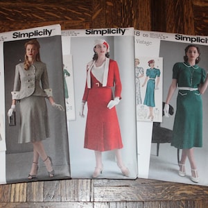 May include: Three Simplicity sewing pattern envelopes featuring 1940s vintage style clothing. The left envelope is gray, the center is red and white, and the right is green and white. Each envelope displays illustrations of dresses, jackets, and skirts.