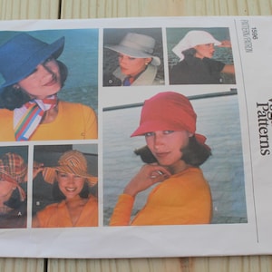 May include: A Vogue Patterns sewing pattern envelope, number 1596, featuring illustrations of various hat styles. The images display a blue bucket hat, a light gray hat, a white headscarf, a red cap, and two different plaid bucket hat designs.