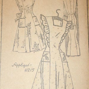 May include: A vintage sewing pattern illustration labeled 2806 featuring two apron designs with floral and fruit motifs, square necklines, and pockets. The text includes Appliqué 1215 and a guarantee statement regarding standard measurements.