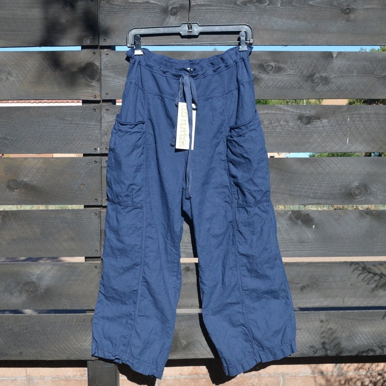 Puede incluir: Pantal&oacute;n ancho de color azul oscuro con cintura de cord&oacute;n y bolsillos grandes. El pantal&oacute;n tiene una etiqueta que dice "La Urbana".