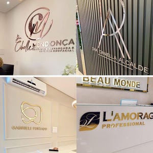 May include: Four different business signs with gold and rose gold lettering. The signs are mounted on white walls and feature the names of the businesses: "Dr. Cibelle Mendonca", "Dra. Daniella Alcalde", "Beau Monde", and "L'Amorag Professional".