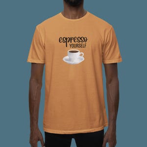 Puede incluir: Una camiseta naranja claro con el texto "espresso yourself" y una imagen de dibujos animados de una taza de café.