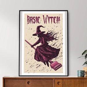 Puede incluir: Una ilustración en blanco y negro de una bruja volando en una escoba con el texto "BASIC WITCH" encima de ella. La bruja lleva un sombrero puntiagudo y un vestido largo. El fondo es de color beige claro con salpicaduras negras.