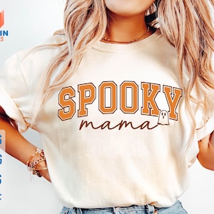May include: Cream-colored t-shirt with the words "SPOOKY mama" in orange and brown lettering, featuring a ghost graphic. The shirt is part of a Halloween-themed design, with SVG, PNG, EPS, and DXF file options.