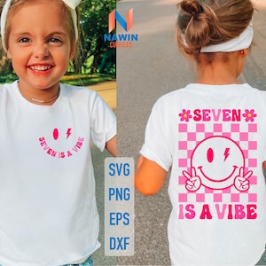 Puede incluir: Camiseta blanca con una carita sonriente rosa y el texto "SEVEN IS A VIBE". El diseño incluye un rayo y un patrón de tablero de ajedrez. La camiseta la lleva una persona joven.