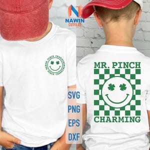 Puede incluir: Dos camisetas blancas con un diseño a cuadros verde y blanco y una cara sonriente con tréboles para los ojos. El texto "MR. PINCH CHARMING" está impreso en las camisetas.