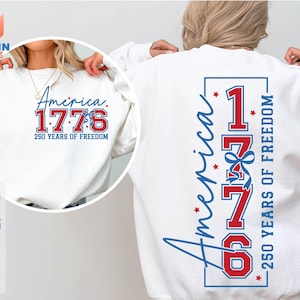 May include: White sweatshirt with the text "America 1776 250 Years of Freedom" in red and blue. The design is on the front and back of the sweatshirt. The sweatshirt is a crew neck style.