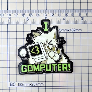 以下が含まれることがあります： 画面にハートのシンボルが表示されたコンピューターを持った、黒い目と黒い鼻を持つ白い漫画の猫のステッカー。猫は黒いシャツを着ており、緑色の吹き出しに「I <3 COMPUTER!」と書かれています。