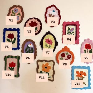 Pode incluir: Uma cole&ccedil;&atilde;o de doze obras de arte t&ecirc;xtil floral emolduradas e coloridas. Cada pe&ccedil;a apresenta um design floral &uacute;nico em v&aacute;rias cores, incluindo rosa, vermelho, laranja e azul, com uma apar&ecirc;ncia texturizada e feita &agrave; m&atilde;o. As pe&ccedil;as est&atilde;o rotuladas de V1 a V12.
