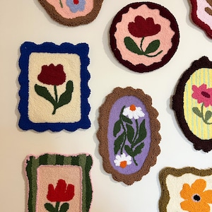 Pode incluir: Uma cole&ccedil;&atilde;o de tape&ccedil;arias de parede coloridas e texturizadas com desenhos florais. Cada pe&ccedil;a apresenta uma flor diferente, incluindo tulipas e margaridas, em tons de vermelho, azul e laranja, sobre fundos neutros e emolduradas com bordas decorativas.