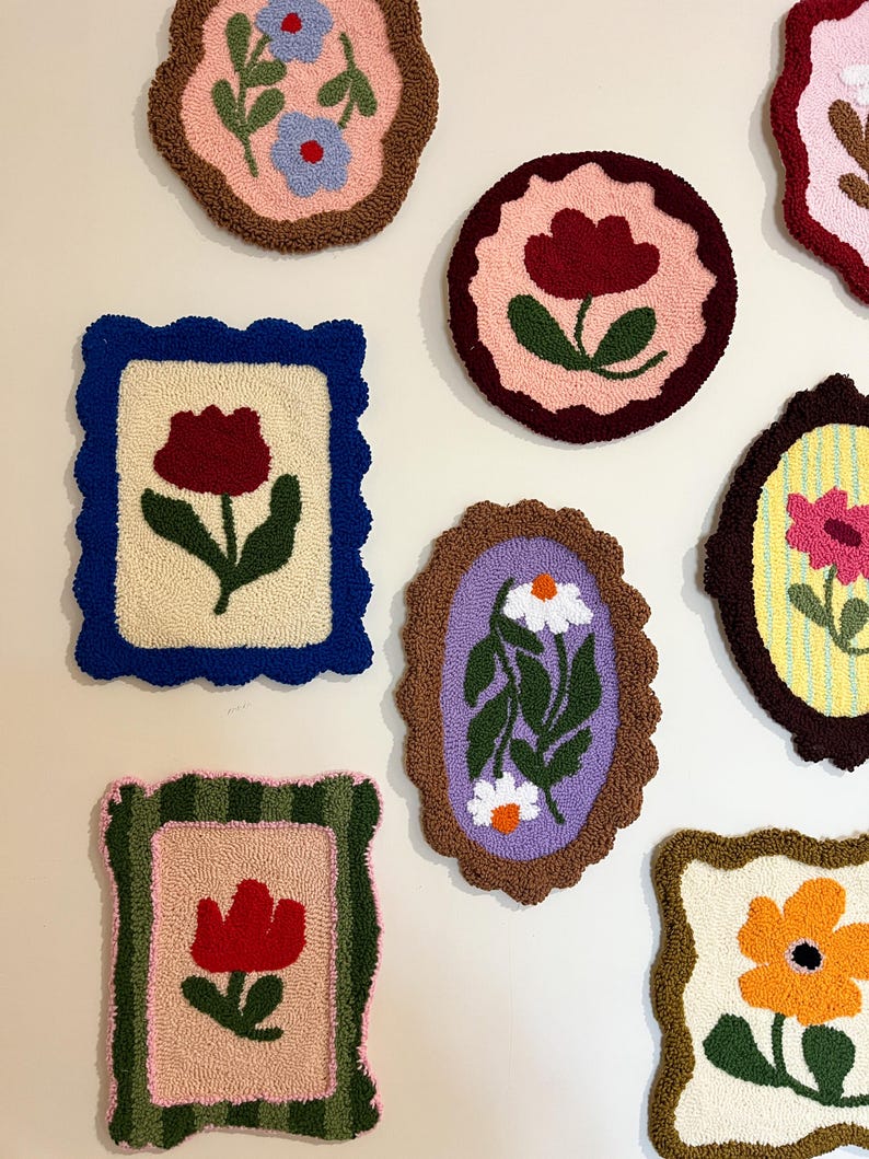 Pode incluir: Uma cole&ccedil;&atilde;o de tape&ccedil;arias de parede coloridas e texturizadas com desenhos florais. Cada pe&ccedil;a apresenta uma flor diferente, incluindo tulipas e margaridas, em tons de vermelho, azul e laranja, sobre fundos neutros e emolduradas com bordas decorativas.