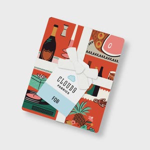 May include: A stack of folded fabric with a red background featuring illustrations of champagne bottles, pineapples, and gingerbread men. A white ribbon is tied around the bundle, holding a tag that reads CLOUD9 FABRICS and FQB in black text.