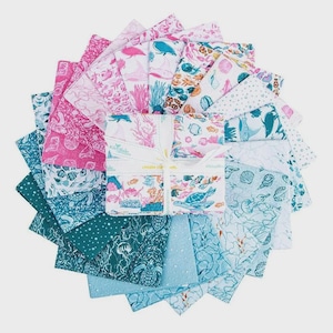 May include: A collection of fabric squares in shades of pink, teal, and white, featuring sea life patterns. The fabrics are arranged in a circular pattern, with a central bundle tied with a ribbon. The fabrics have images of coral, fish, and turtles.