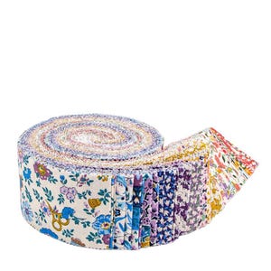 May include: A rolled bundle of floral fabric strips. The fabric features a variety of colorful floral patterns, including blue, purple, and yellow flowers on a white background. The roll is partially unraveled, revealing the different fabric designs.