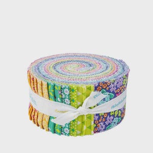 May include: A rolled bundle of colorful fabric strips, featuring a variety of floral and geometric patterns in shades of yellow, green, blue, and purple. The fabric is secured with a white ribbon tied in a bow. The text "#RileyBlakeDesigns" is visible on the ribbon.