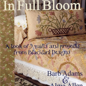 May include: A book cover titled "In Full Bloom" featuring a floral design on a pillow. The text reads "A look of 9 quilts and projects from Blackbird Designs" and "Barb Adams & Alma Allen". The style is vintage cottage.