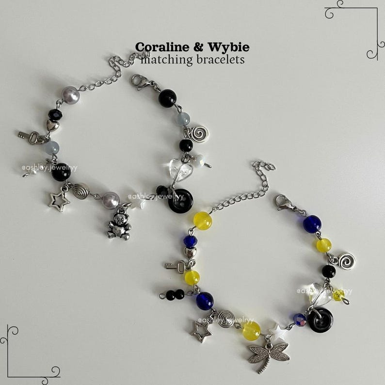 May include: Two matching bracelets with silver chains, featuring beads in black, yellow, blue, and grey. Charms include stars, keys, a teddy bear, and a dragonfly. The text "Coraline & Wybie matching bracelets" is visible.
