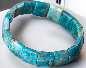 May include: A turquoise blue gemstone bracelet with square-shaped beads. The bracelet is made of natural stones and has a polished finish.