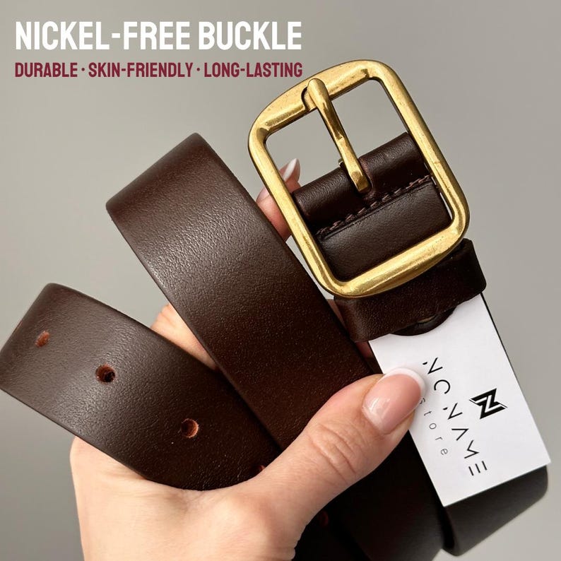 May include: A dark brown leather belt featuring a gold-toned rectangular buckle. The text NICKEL-FREE BUCKLE, DURABLE, SKIN-FRIENDLY, LONG-LASTING is visible. A white tag attached to the belt displays the logo and text NO NAME store.