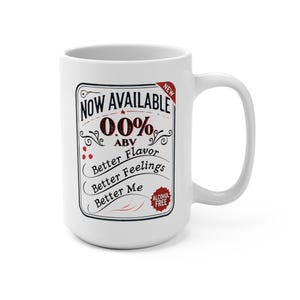May include: White ceramic mug with a black and red design that says "NOW AVAILABLE 0.0% ABV Better Flavor Better Feelings Better Me ALCOHOL FREE" with a red star and a red "NEW" label.