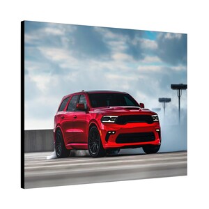 May include: A red Dodge Durango SRT is driving on a paved road with smoke coming from the tires. The SUV is in motion and the background is a cloudy sky.