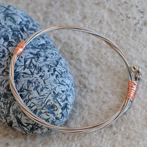 May include: A silver and copper guitar string bracelet with a copper wire wrap at each end.