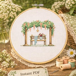 May include: A cross-stitch design in a wooden hoop, depicting a garden scene with a bench under a trellis. The text "Cynthia's Garden" and "Cross Stitch Pattern" are at the top. A tag reads "Instant PDF Download".