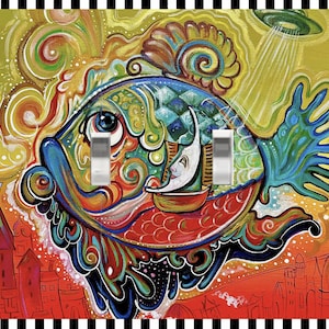 May include: A colorful light switch cover featuring a whimsical fish design. The artwork includes a vibrant palette of blues, greens, reds, and yellows, with a cityscape at the bottom. The cover has three light switches.