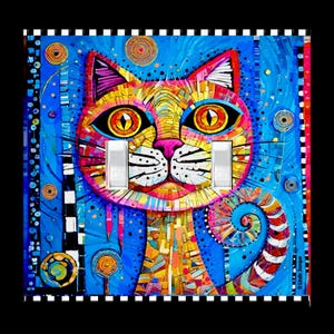 May include: A double light switch wall plate featuring a vibrant, mosaic-style illustration of a cat. The cat has large orange eyes, a pink nose, and a multicolored coat in shades of yellow, red, and blue. The background is a bright blue.