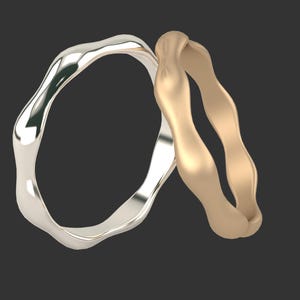 May include: Two wavy wedding bands, one silver and one gold, are intertwined.