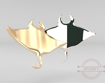 Peut inclure: Deux pendentifs en forme de raie manta, l'un en or et l'autre en argent, avec une finition lisse et polie. Les pendentifs sont suspendus en l'air sur un fond blanc.